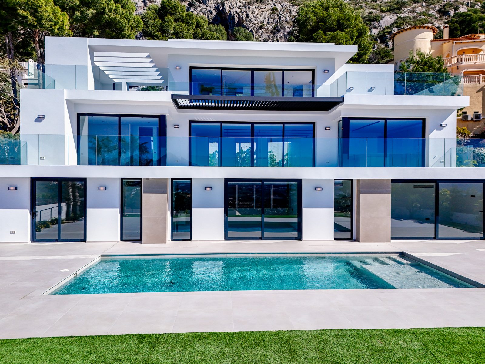 Modern villa facade with glass balconies and swimming pool in Altea - The Estates