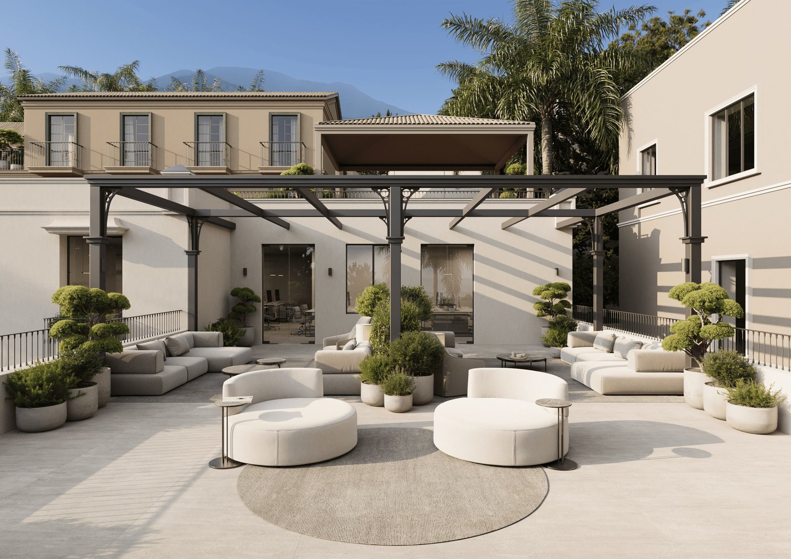 A landscaped courtyard terrace with pergola, outdoor seating, palms and mountain views of a property in Málaga - The Estates