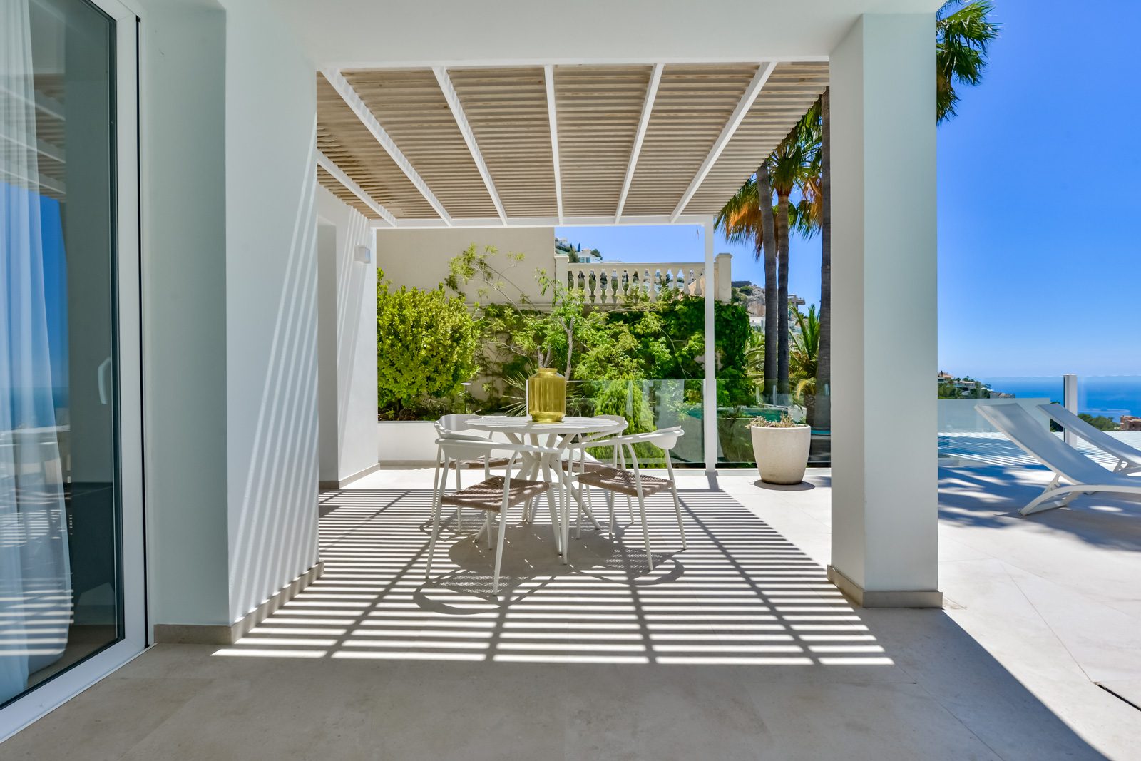 A covered terrace with seating and views of the sea at a 3-bedroom villa in Altea - The Estates