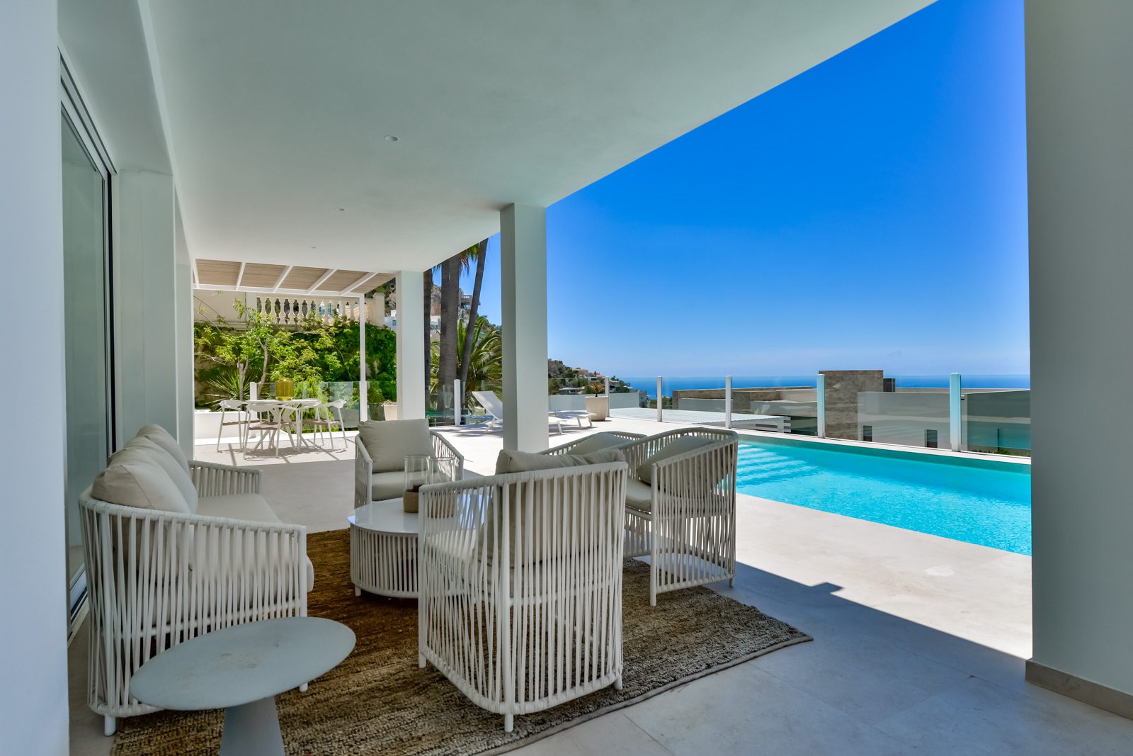 A bright outdoor lounge area and pool with stunning sea views of a 3-bedroom villa in Altea - The Estates