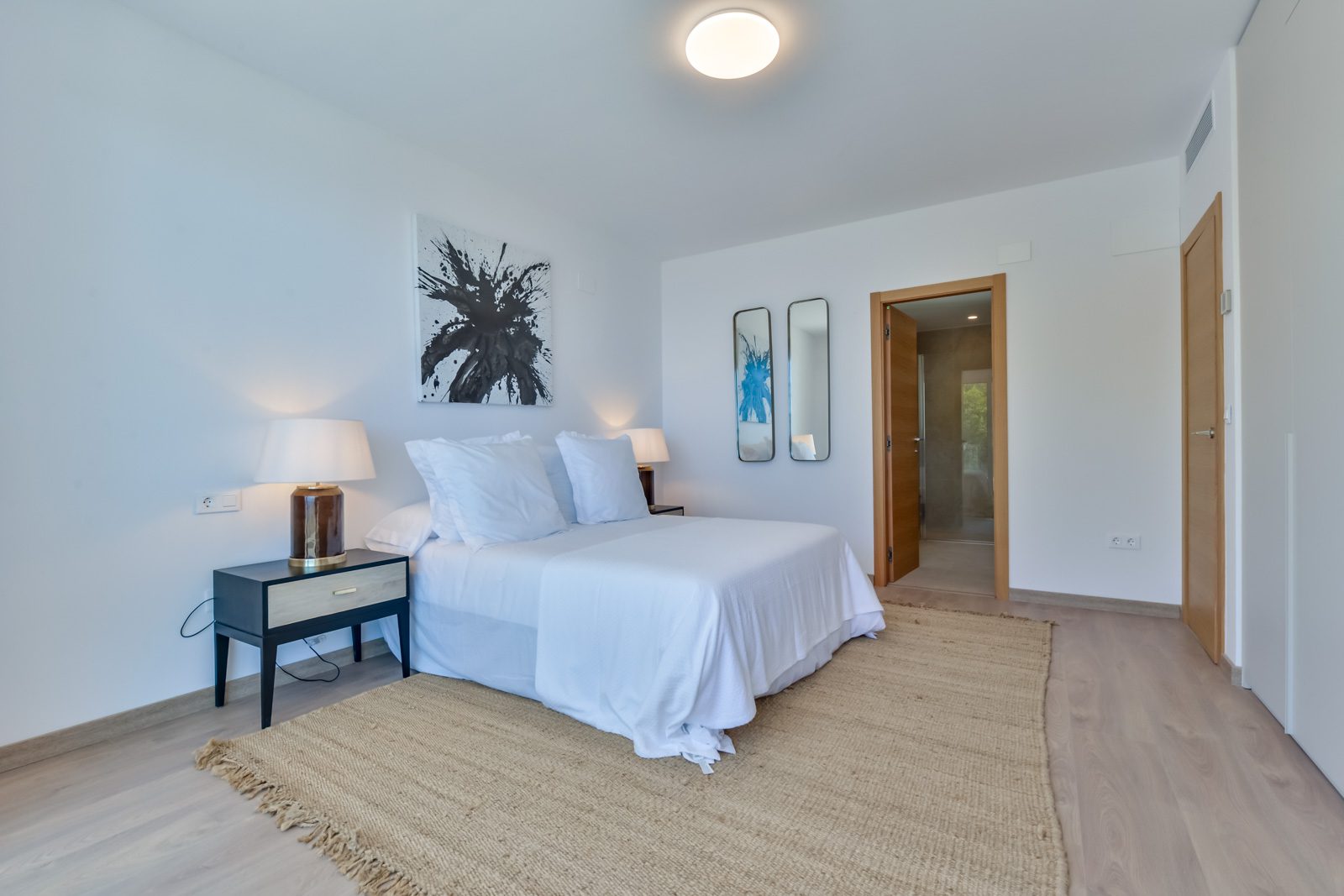 A bright bedroom with a king-size bed and modern decor in a 3-bedroom villa in Altea - The Estates