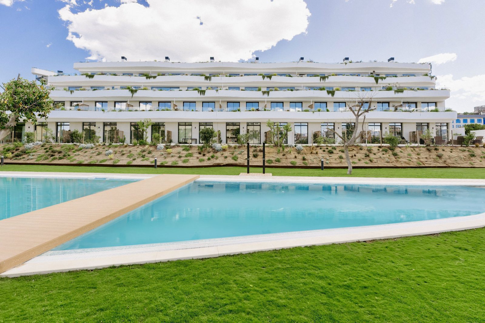 A modern apartment building and swimming pool area of a 3-bedroom apartment in Alfaz del Pi - The Estates