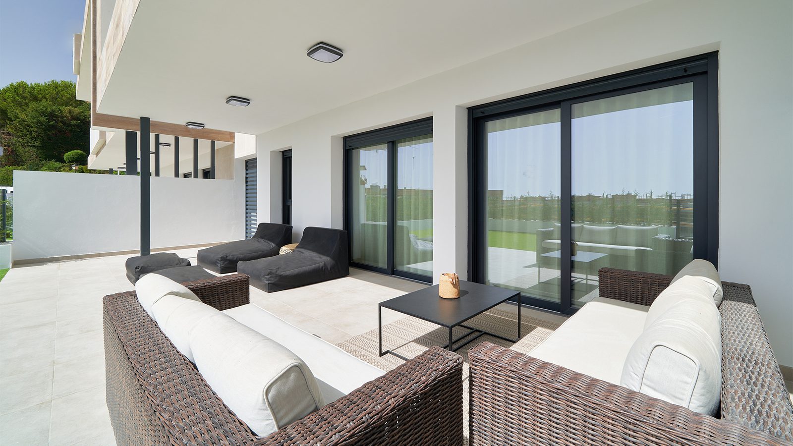 Spacious furnished terrace with outdoor lounge seating overlooking the golf course of a 3-bedroom apartment in Estepona - The Estates