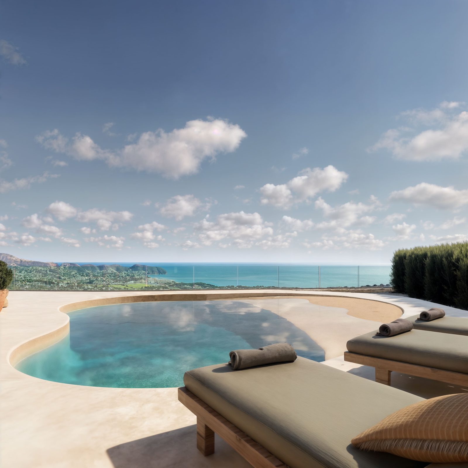 A stunning pool and sun loungers with sea and city views of a 4-bedroom villa in Moraira - The Estates