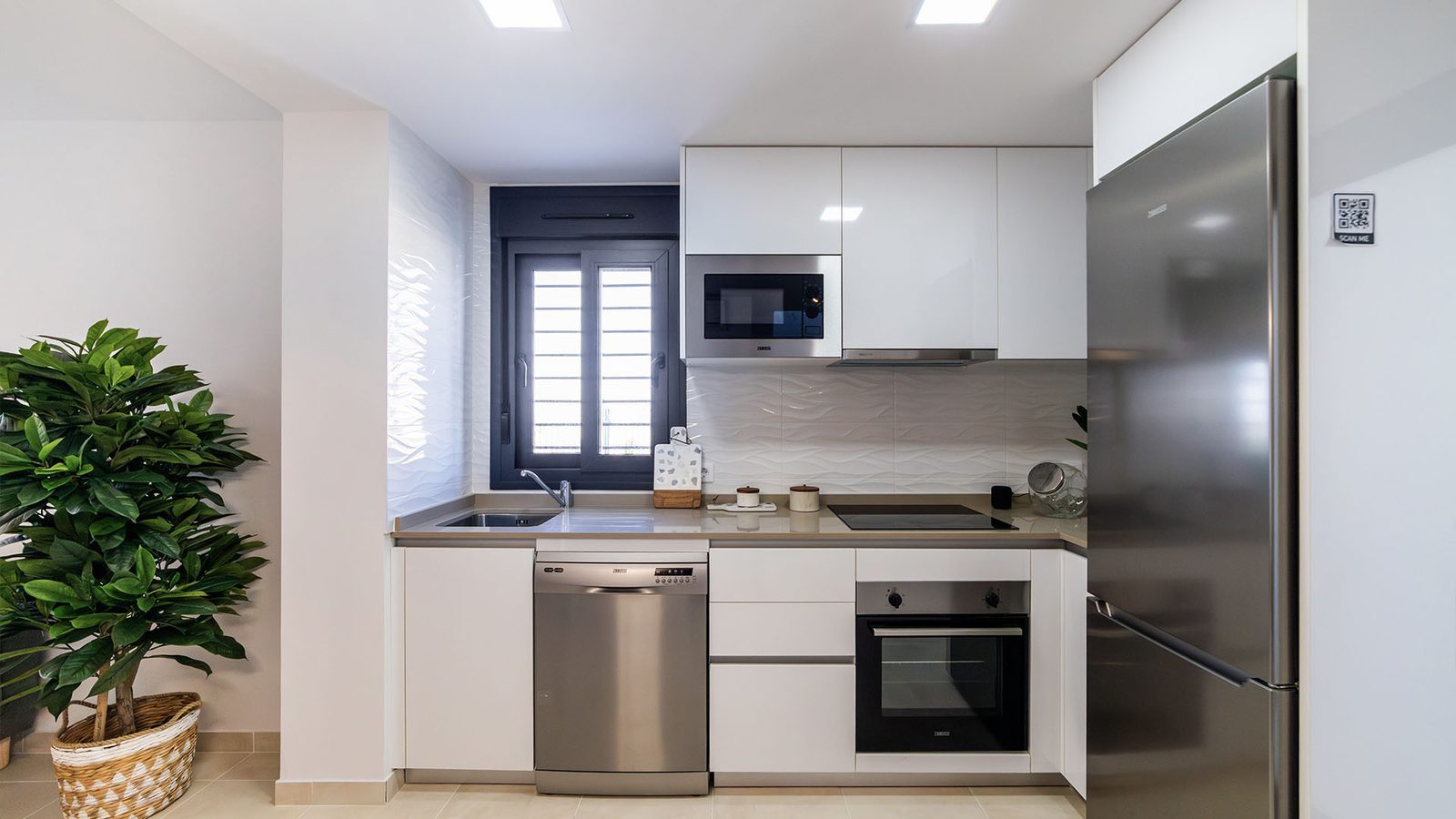 Modern fitted kitchen with white cabinetry and stainless-steel appliances in a 3-bedroom villa in Busot, zona Bonalba Golf - The Estates