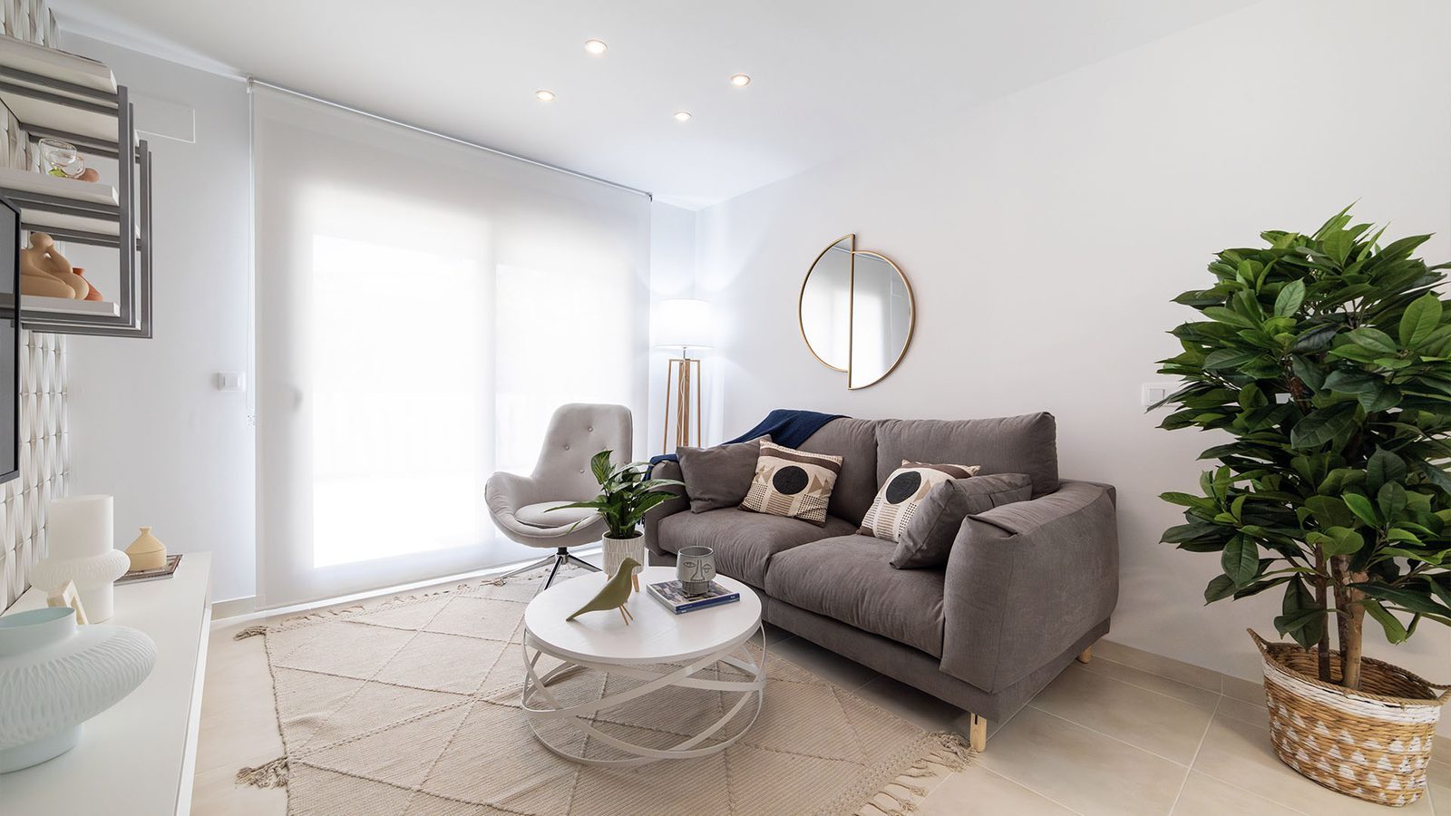 Bright modern living room with grey sofa, coffee table and large potted plant in a 3-bedroom villa in Busot, zona Bonalba Golf - The Estates