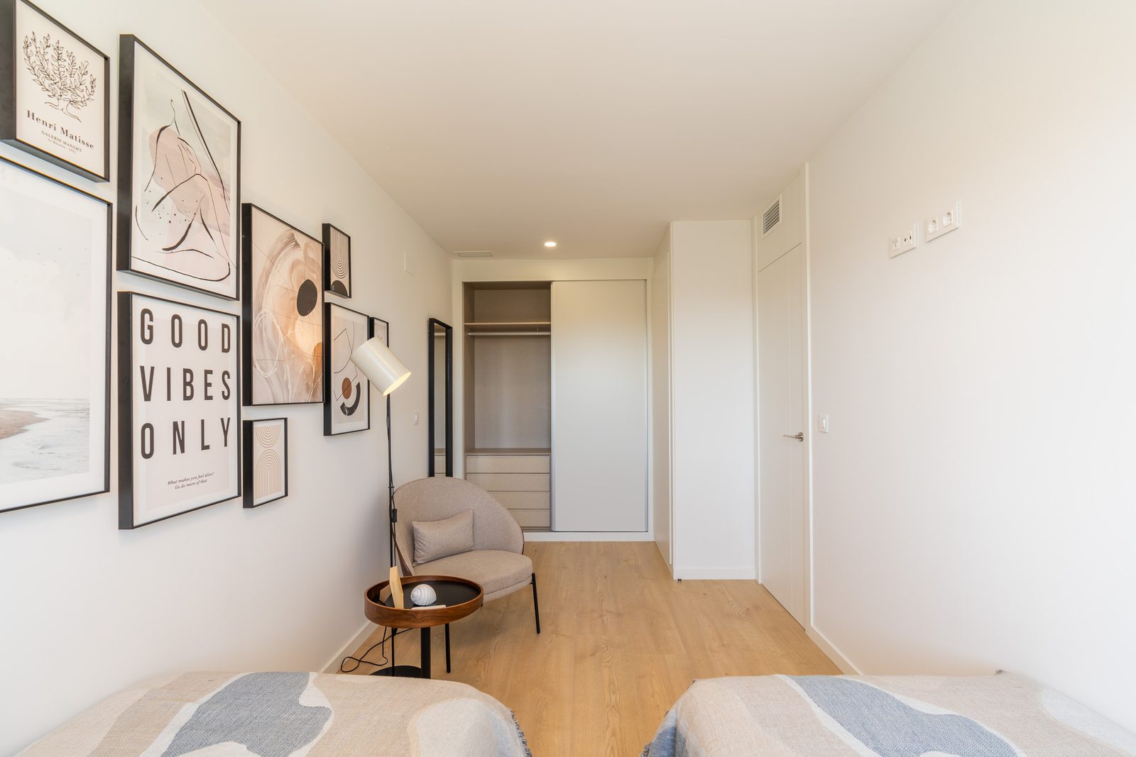 Stylish bedroom interior with artwork and a cozy armchair in a 4-bedroom townhouse in La Nucía - The Estates