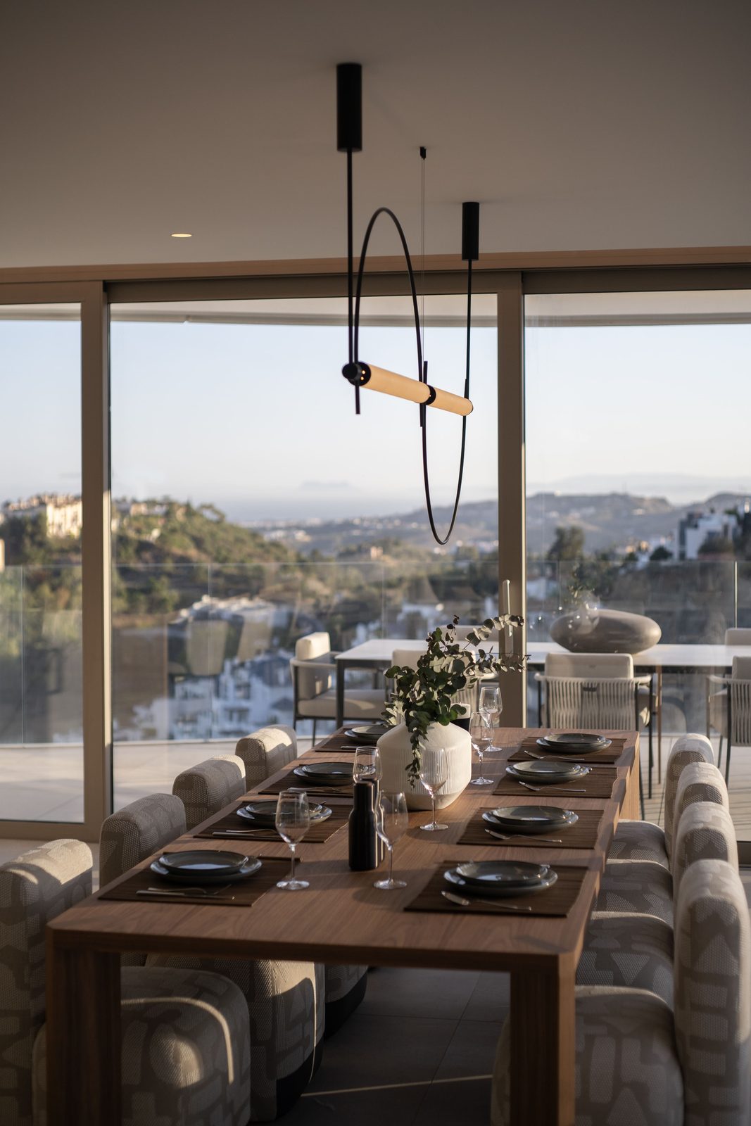 Elegant dining room with a set table, pendant lighting and sea views of a