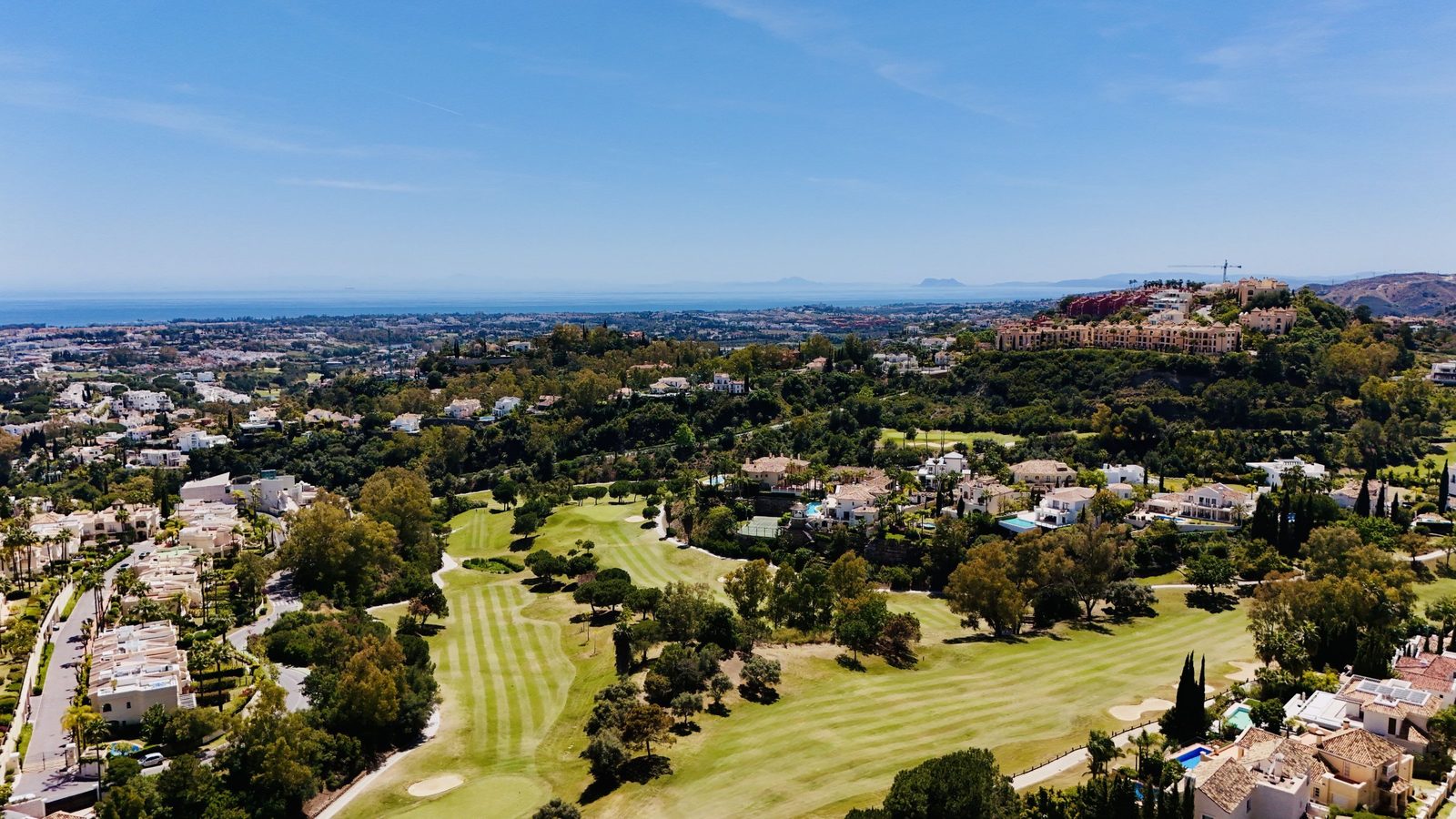 Aerial view of a golf course, villas and Mediterranean Sea in Benahavís, of a 4-bedroom penthouse in Málaga - The Estates