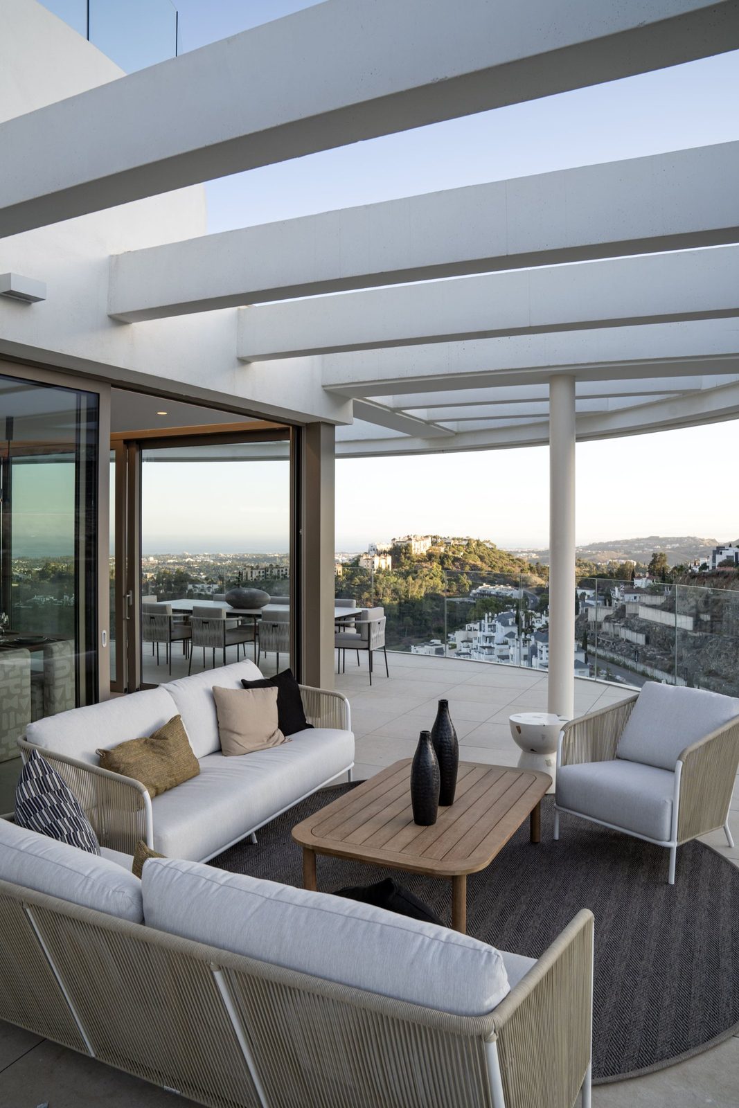 Covered terrace lounge with outdoor seating and panoramic sea views of Benahavís - The Estates