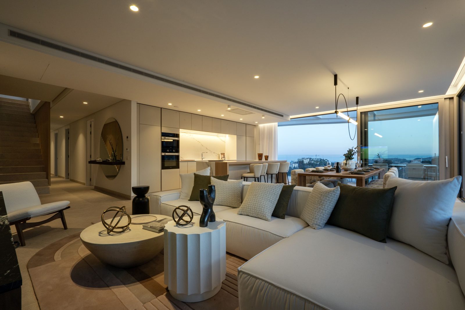 Contemporary open-plan living room and kitchen with sea views in a 4-bedroom penthouse in Málaga - The Estates