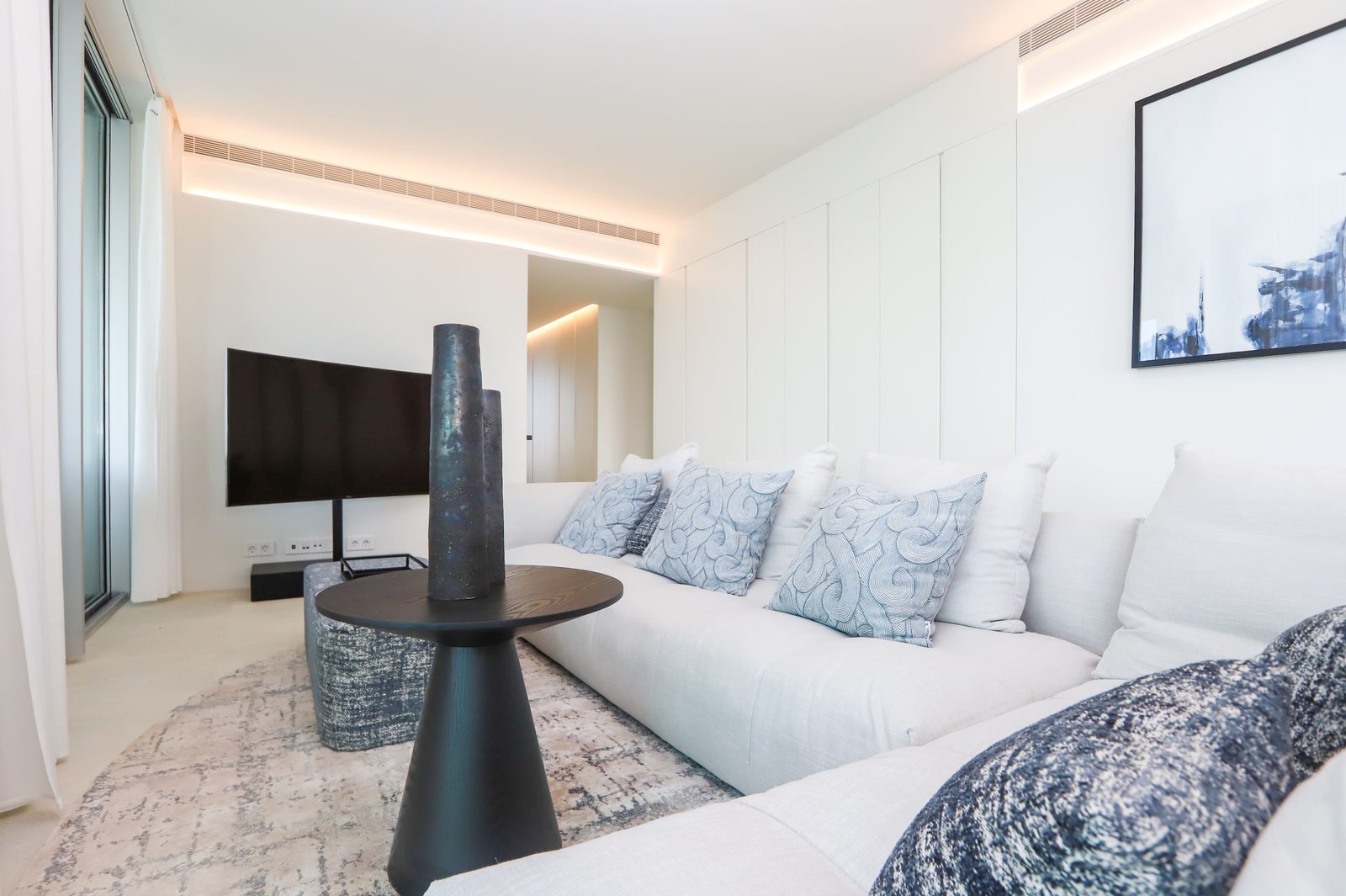 Stylish living room with a large TV and modern decor in a 4-bedroom apartment in Calpe - The Estates
