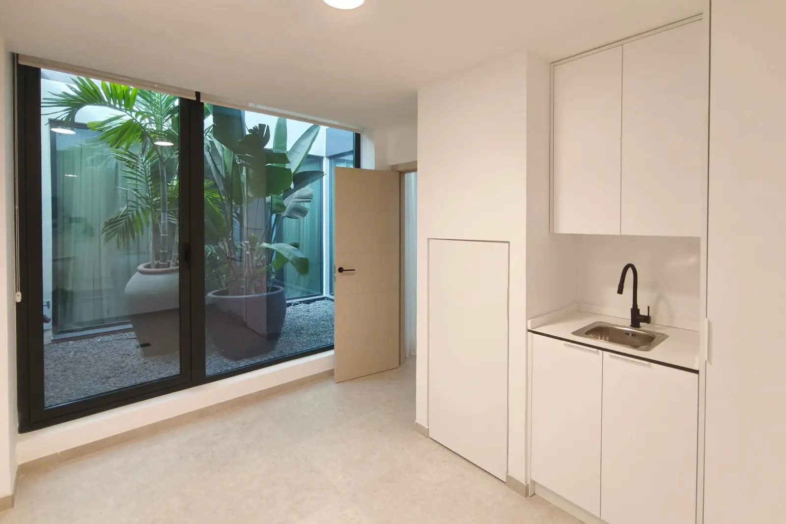 A modern bathroom with a view of a lush courtyard in a 4-bedroom villa in La Nucia - The Estates