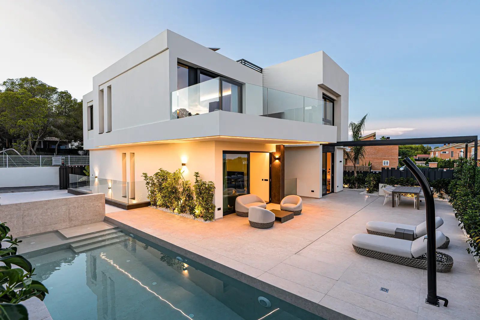 Modern villa exterior with pool and garden, showcasing sea and mountain views - The Estates