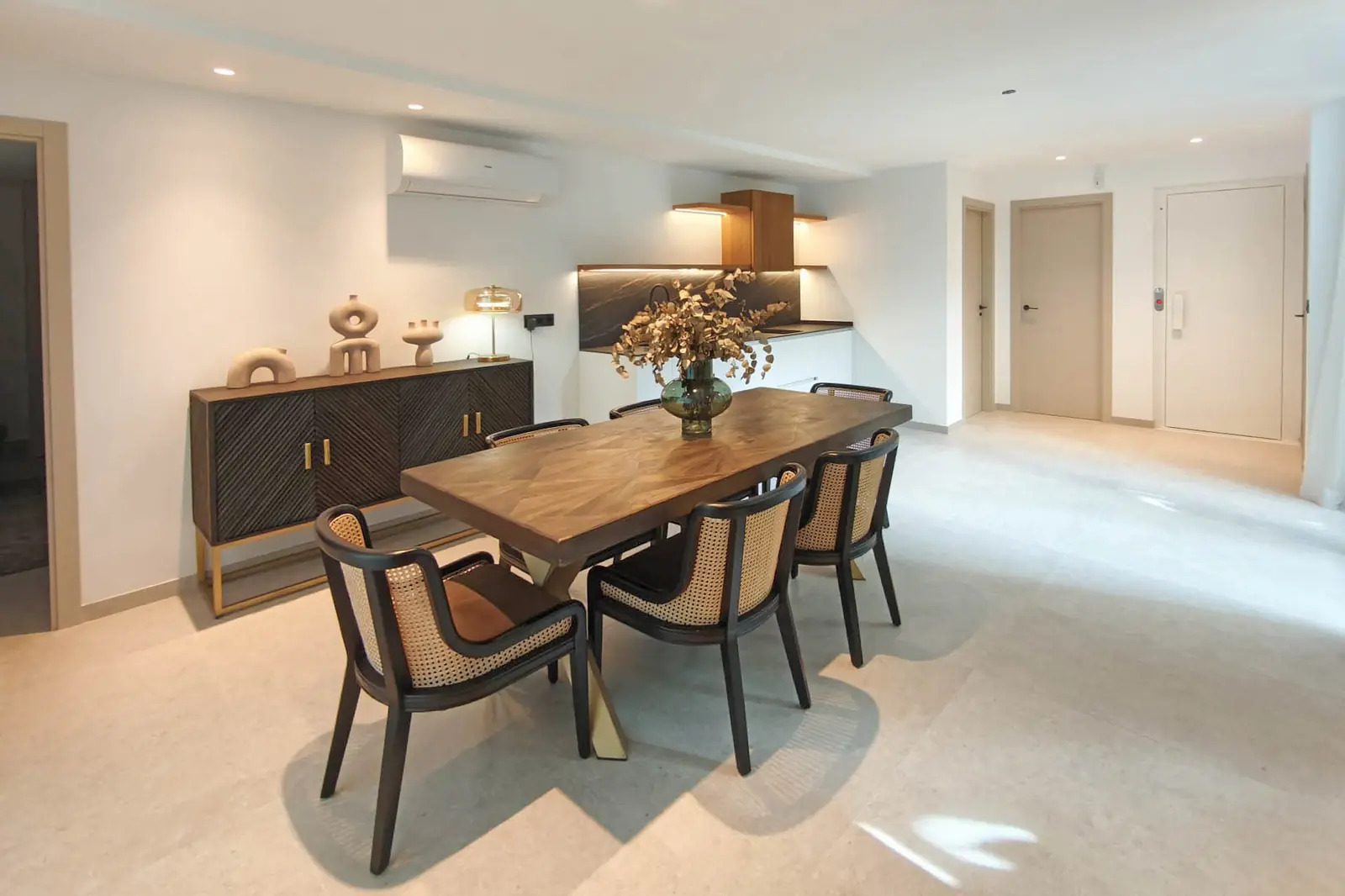 A modern dining area with a dark wood table and chairs in a 4-bedroom villa in La Nucia - The Estates
