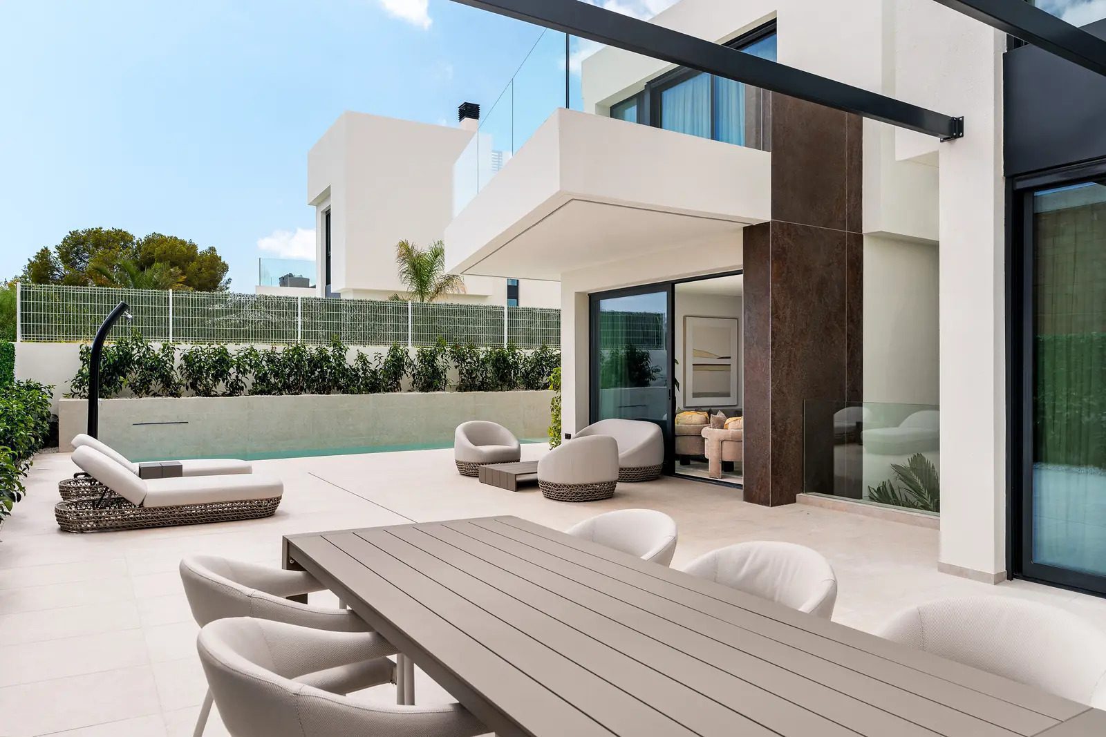 Modern outdoor living space with a dining area and lounge seating at a 4-bedroom villa in La Nucia - The Estates