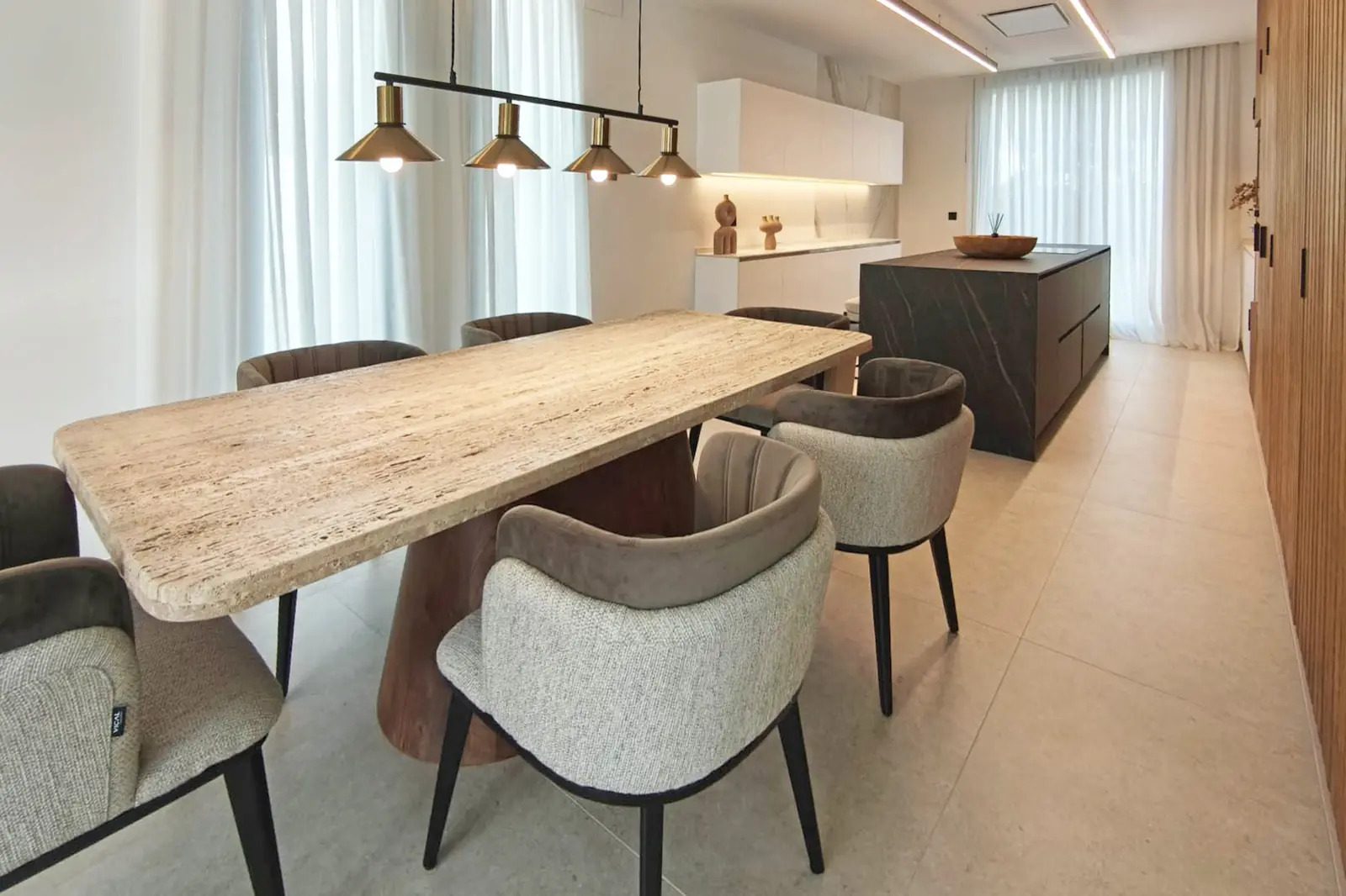 A modern dining area with a large table and stylish chairs in a 4-bedroom villa in La Nucia - The Estates