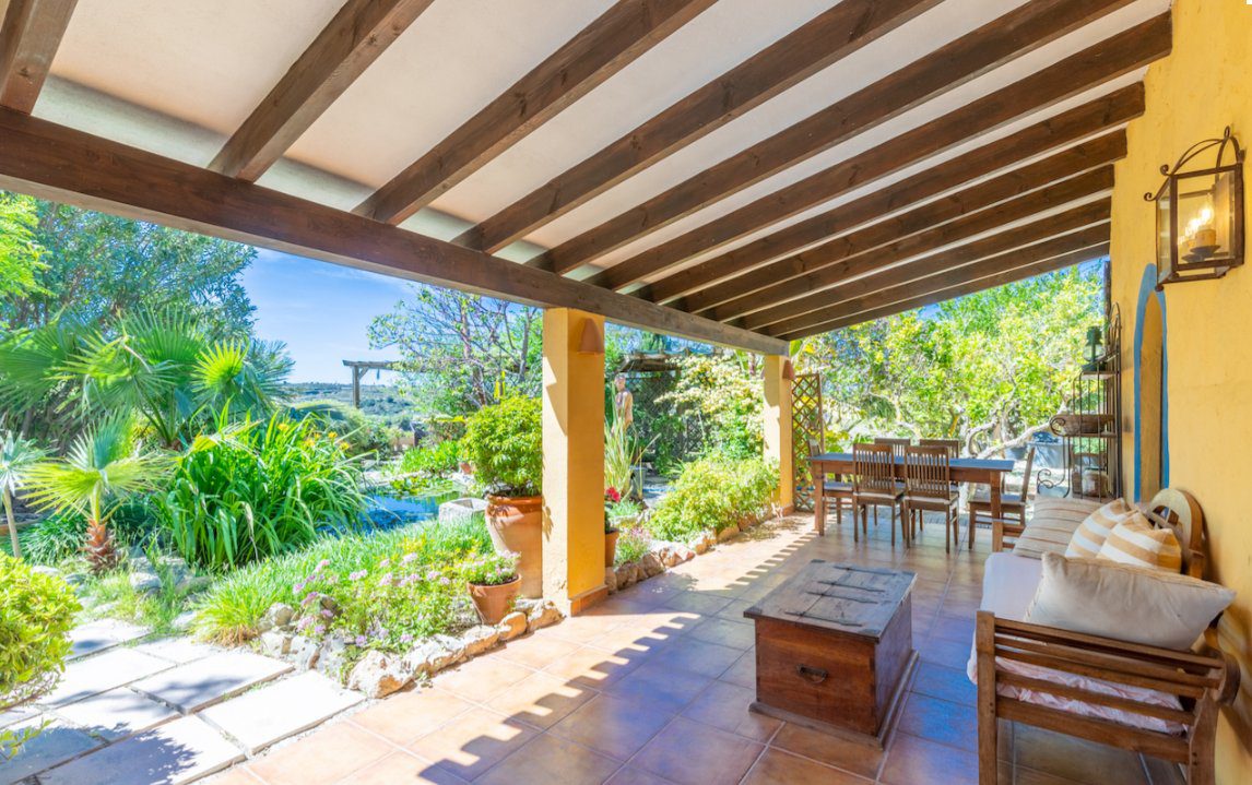 Covered terrace with seating overlooking countryside and sea views of an 8-bedroom finca in Moraira - The Estates