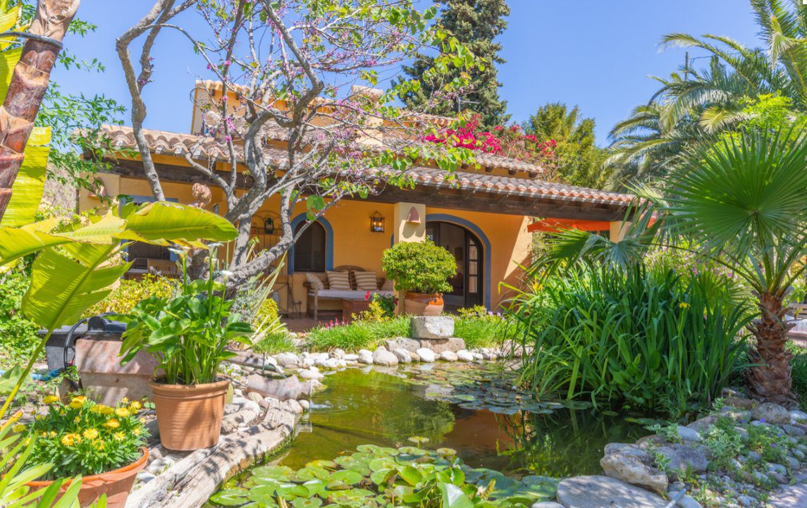 A tranquil garden with a pond and seating area of a 8-bedroom finca in Moraira - The Estates