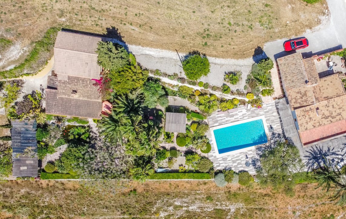 Aerial view of a sprawling 8-bedroom finca with a pool and gardens in Moraira - The Estates