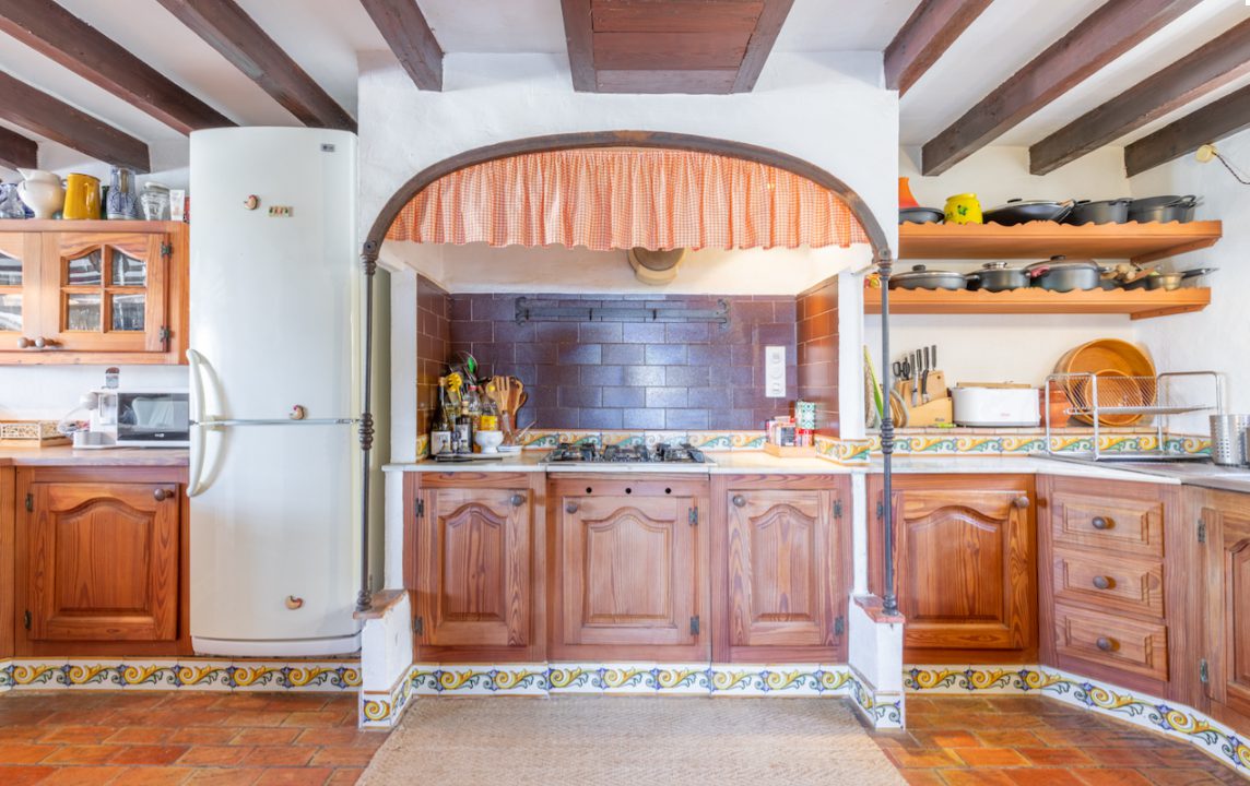 A charming kitchen with exposed beams and tiled details in an 8-bedroom finca in Moraira - The Estates