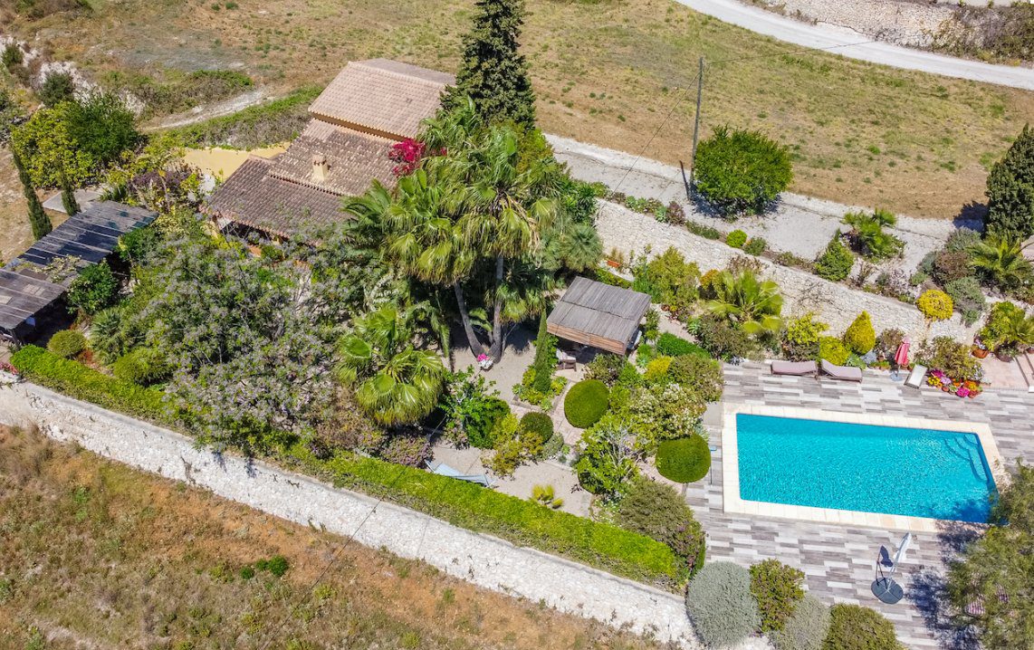 Aerial view of a luxurious 8-bedroom finca with a pool and gardens in Moraira - The Estates