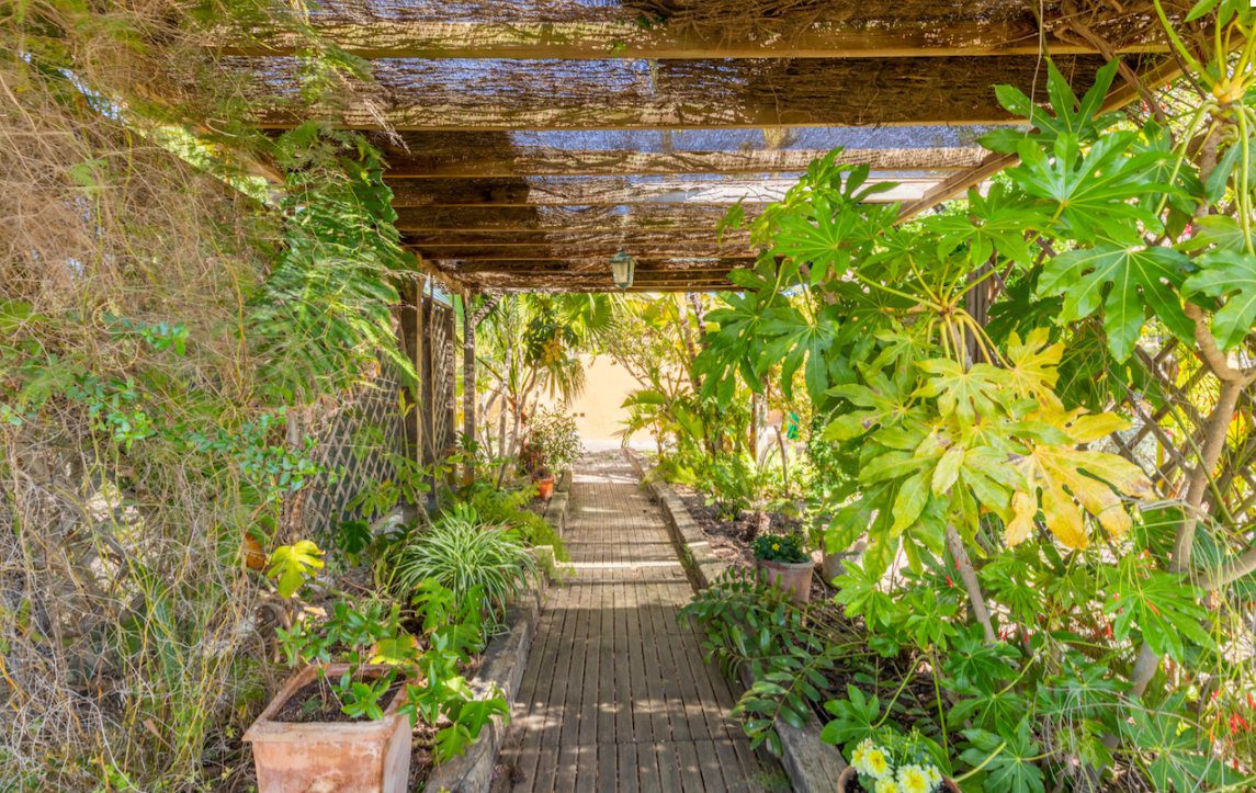 A shaded walkway with lush greenery on an 8-bedroom finca in Moraira - The Estates