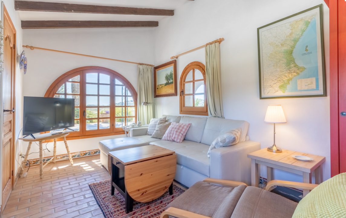A cozy living room with arched windows and countryside views in an 8-bedroom finca in Moraira - The Estates