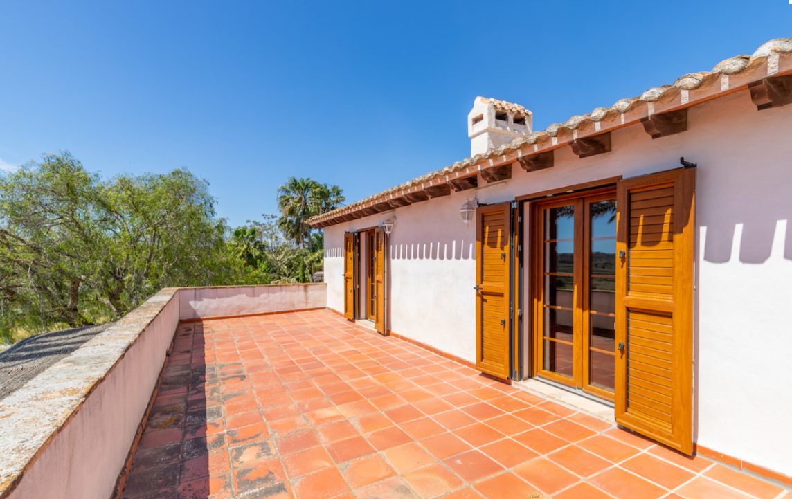 Terrace with wooden doors and tiled floor overlooking countryside views of an 8-bedroom finca in Moraira - The Estates