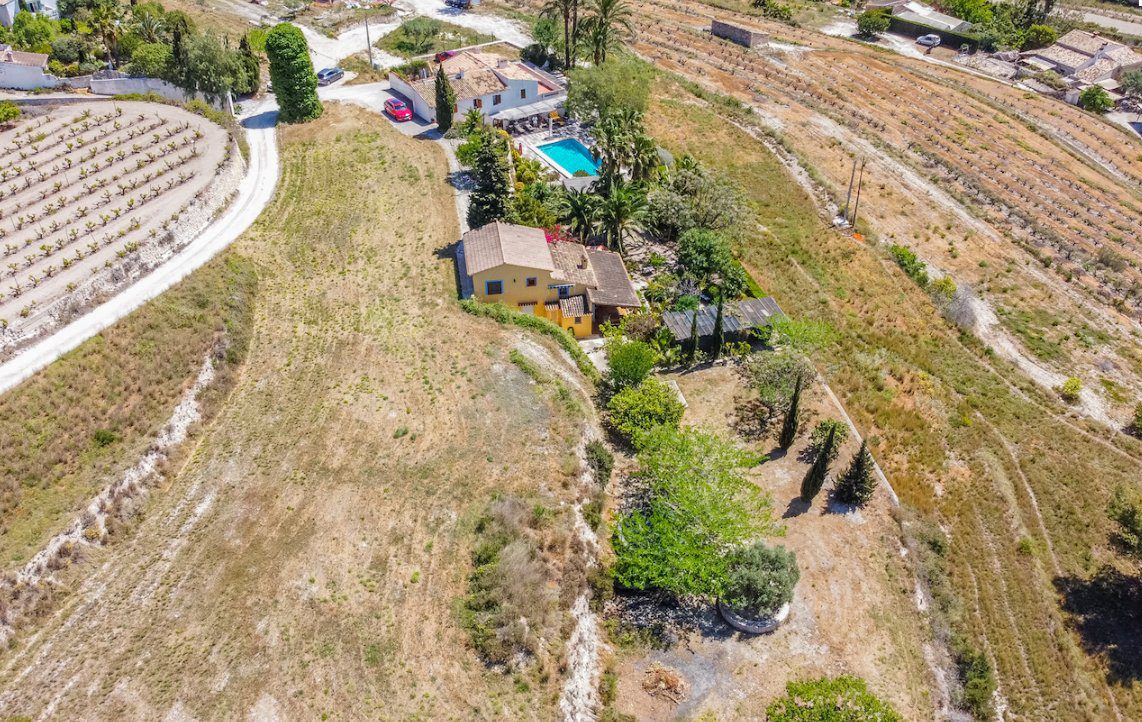 Aerial view of a sprawling finca with a pool and surrounding countryside in Moraira - The Estates