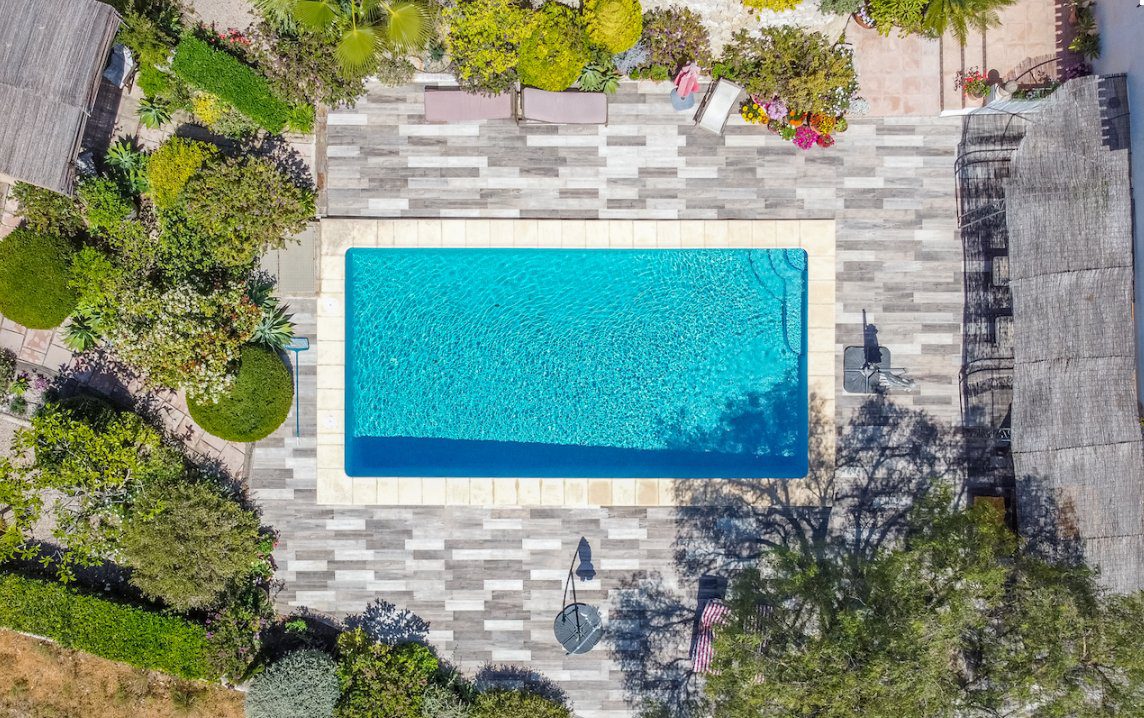 Aerial view of a swimming pool and patio area of an 8-bedroom finca in Moraira - The Estates