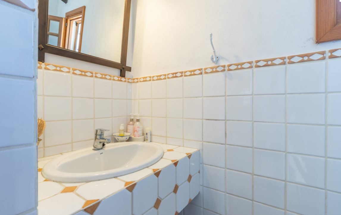 A stylish bathroom with tiled walls and a modern sink in an 8-bedroom finca in Moraira - The Estates