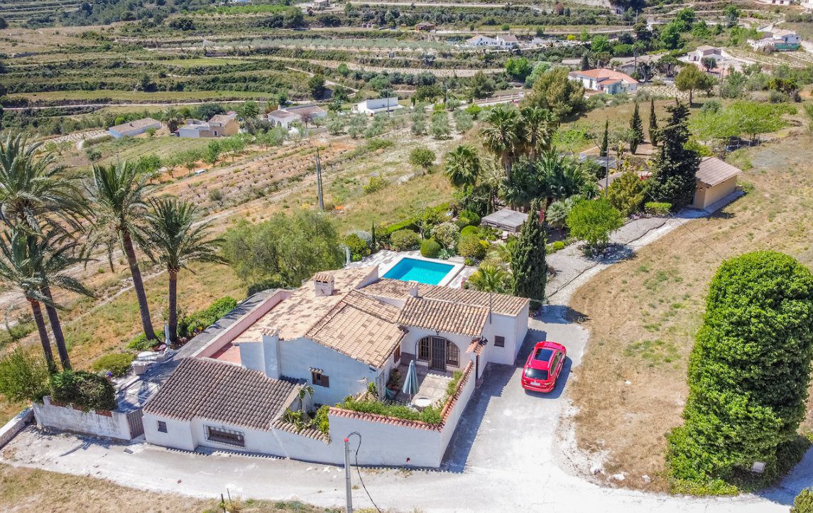 An aerial view of a beautiful finca with a pool and surrounding countryside in Moraira - The Estates