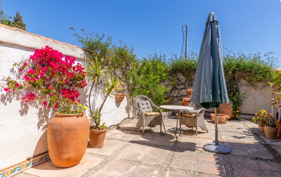 A charming patio with colorful flowers and seating area of an 8-bedroom finca in Moraira - The Estates