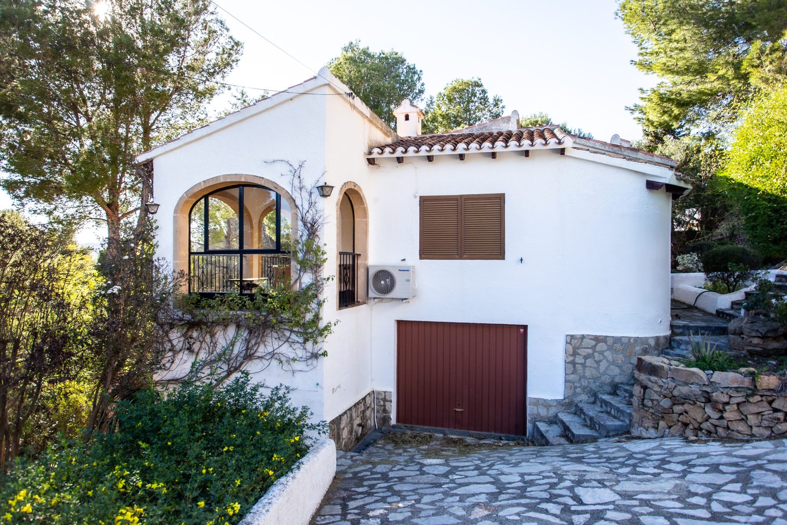 Exterior view of a charming 2-bedroom villa nestled amongst greenery in Javea / Xabia - The Estates