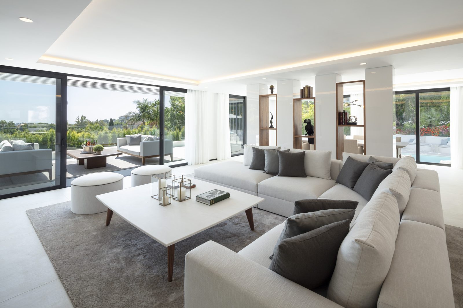 Bright contemporary living room with sectional sofa, coffee table and garden views in a 5-bedroom villa in Málaga - The Estates