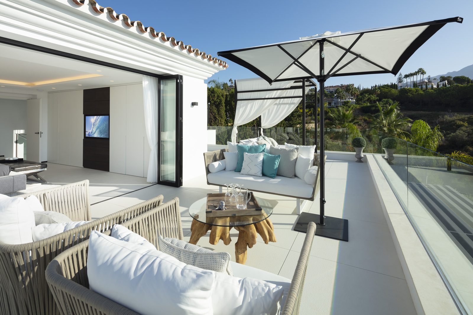 Sun terrace with outdoor lounge seating, parasol and mountain views of a