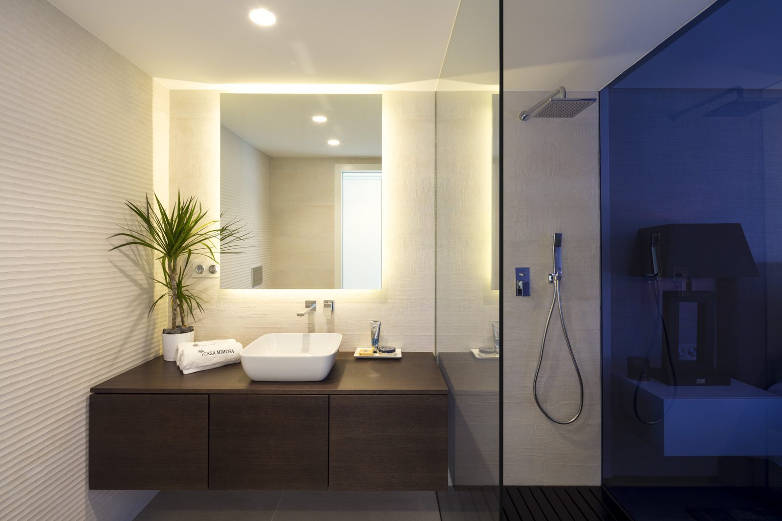 Modern bathroom with double vanity, illuminated mirror and glass walk-in shower in a 5-bedroom villa in Málaga - The Estates