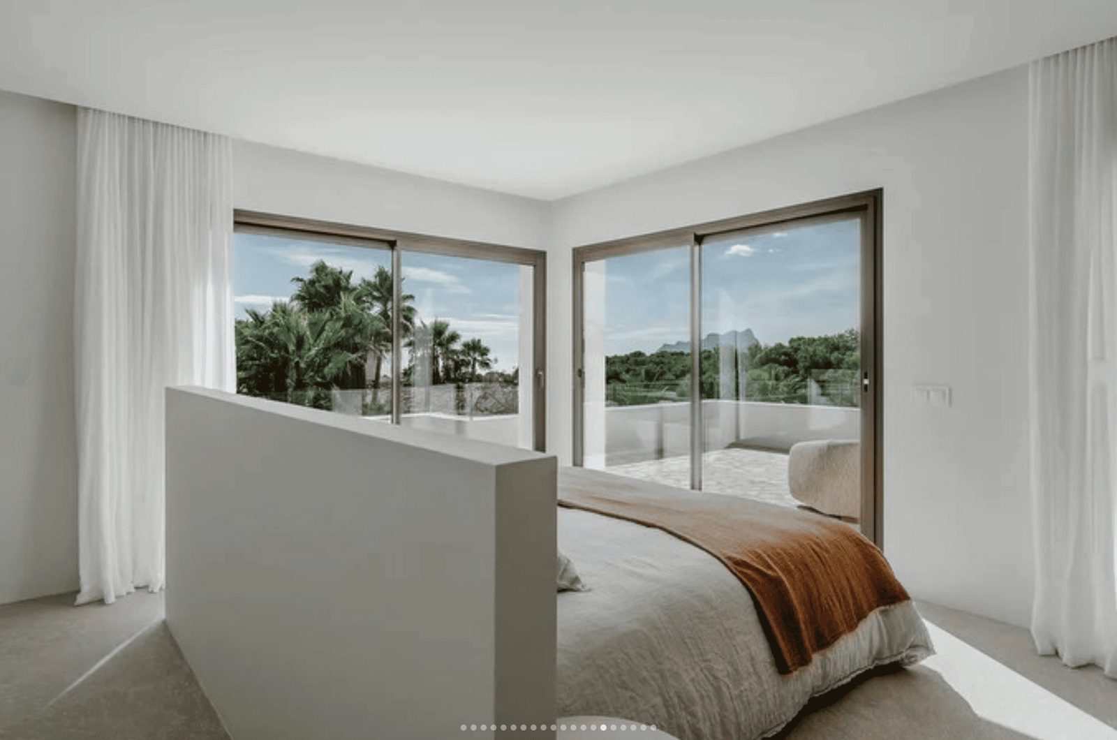 Bright bedroom with sliding doors and a view of lush greenery in a 5-bedroom villa in Benissa - The Estates