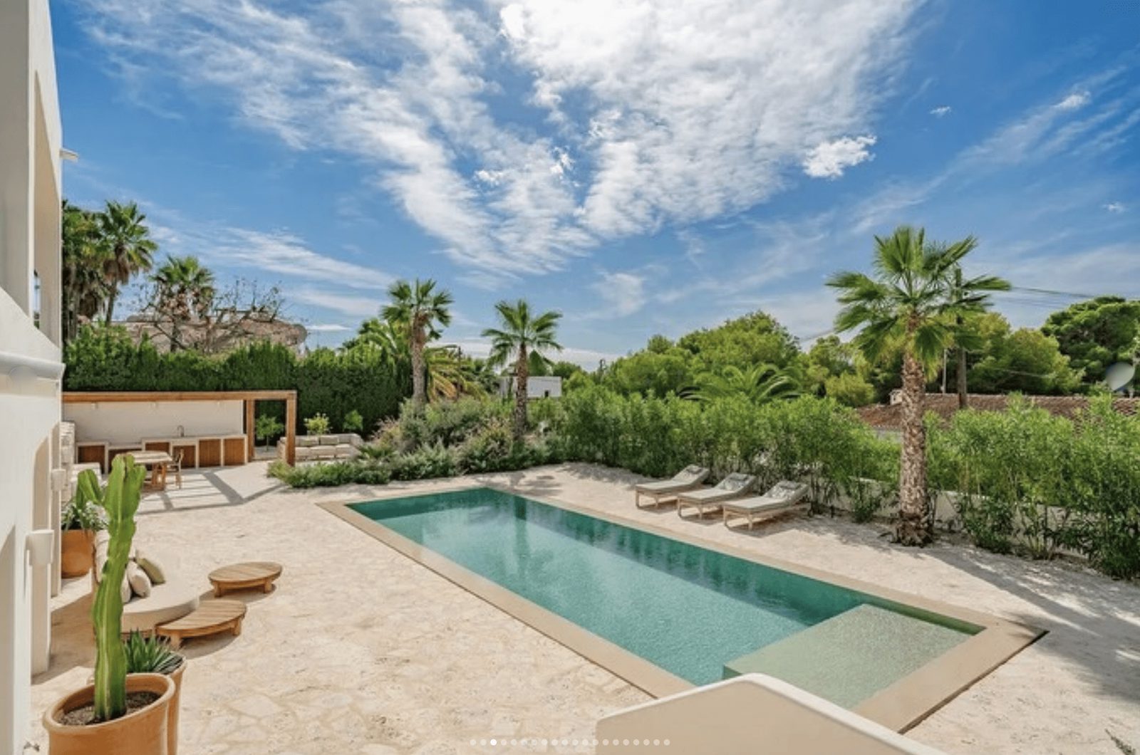 A beautiful pool area with lounge chairs and palm trees at a 5-bedroom villa in Benissa - The Estates