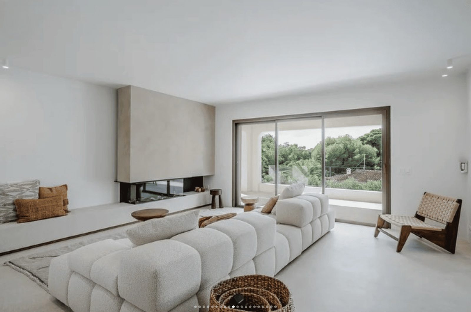 A modern living room with a fireplace and large windows in a 5-bedroom villa in Benissa - The Estates
