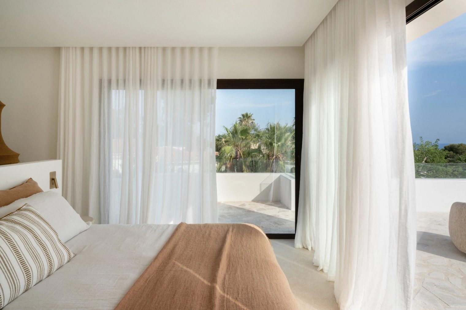 Elegant bedroom with sheer curtains and a view of lush greenery in a 5-bedroom villa in Benissa - The Estates