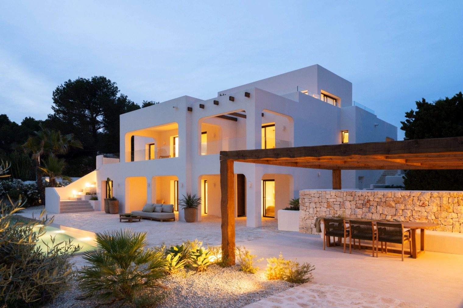 Exterior view of a modern 5-bedroom villa in Benissa, beautifully lit at dusk - The Estates
