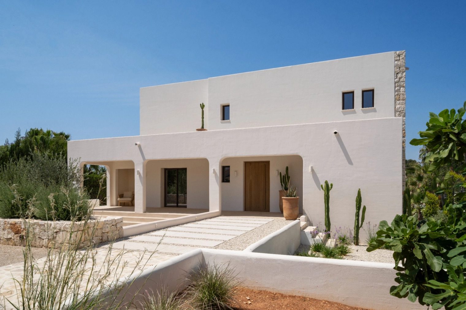 Exterior view of a modern 5-bedroom villa in Benissa, surrounded by lush greenery - The Estates