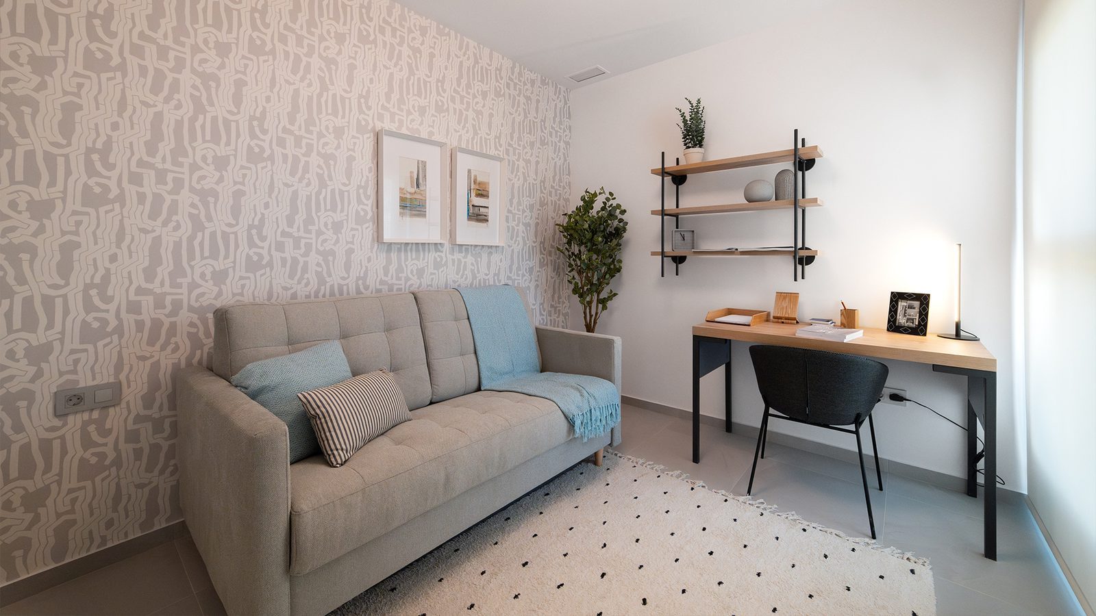Contemporary living room and study area with sofa, desk and shelving in a 2-bedroom apartment in Benidorm - The Estates