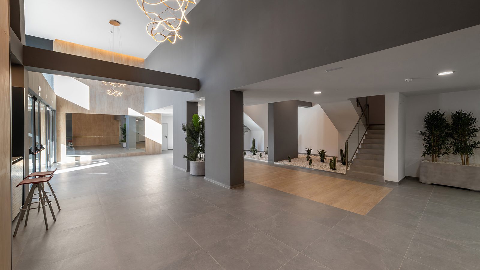 Modern apartment lobby with a staircase, indoor planters and contemporary lighting of a 2-bedroom apartment in Benidorm - The Estates