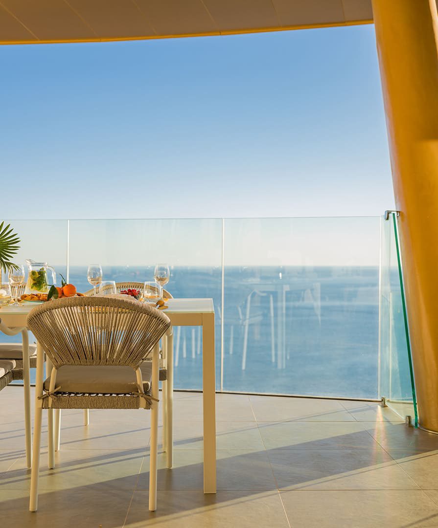 A dining area with panoramic sea views from a 3-bedroom apartment in Benidorm - The Estates