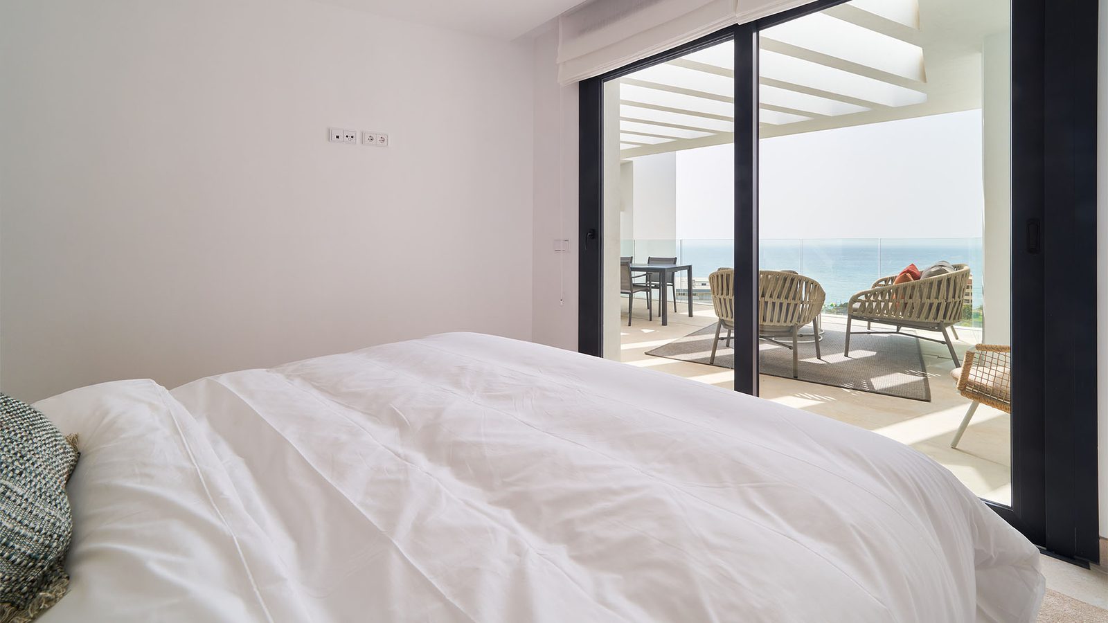 A bright bedroom with balcony access and sea views in a 3-bedroom apartment in Fuengirola - The Estates