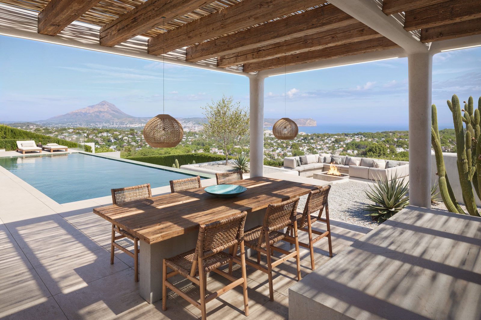 Outdoor dining area and pool with sea views at a 5-bedroom villa in Javea - The Estates