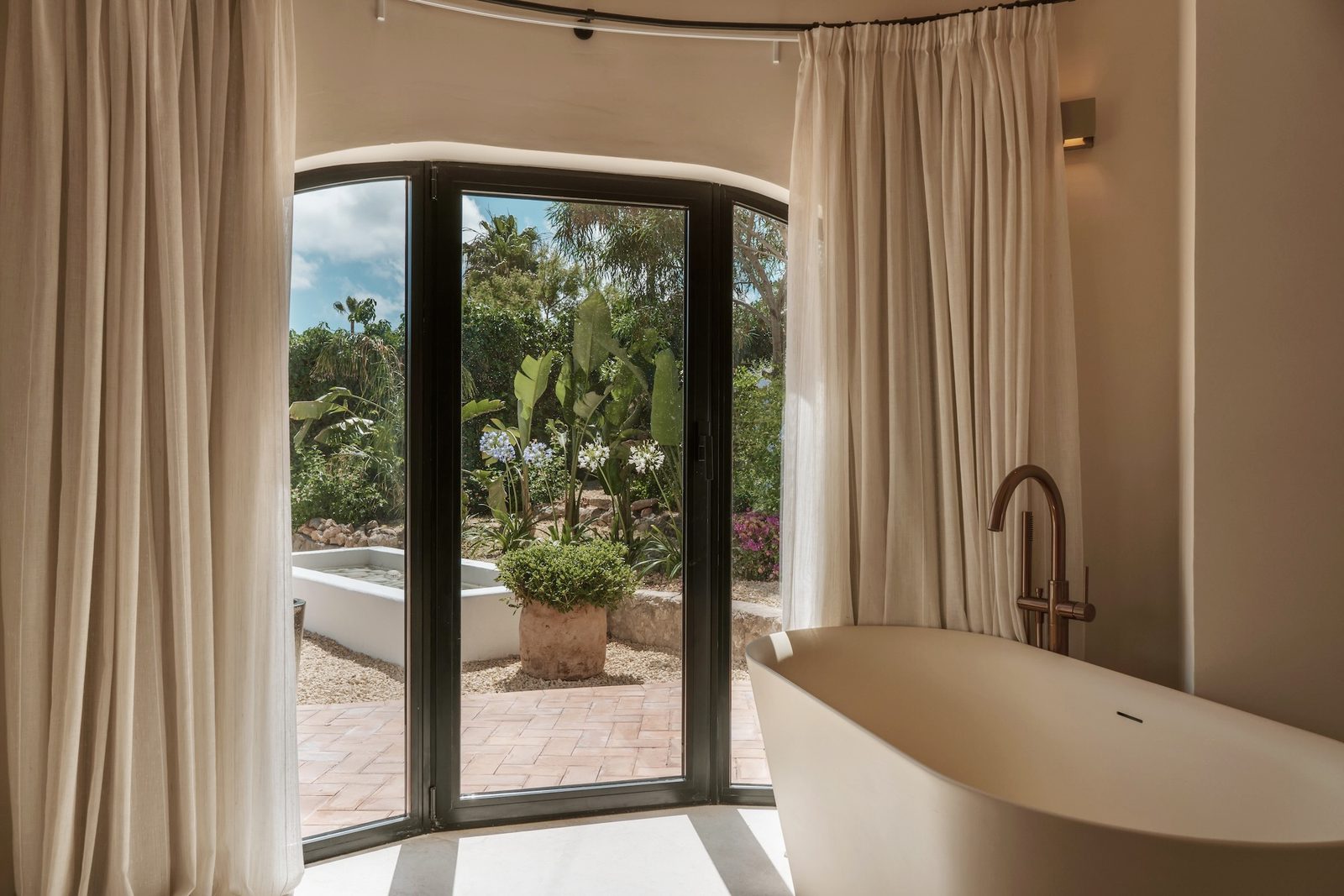 A luxurious bathroom with a freestanding tub and garden views in a 4-bedroom villa in Javea - The Estates